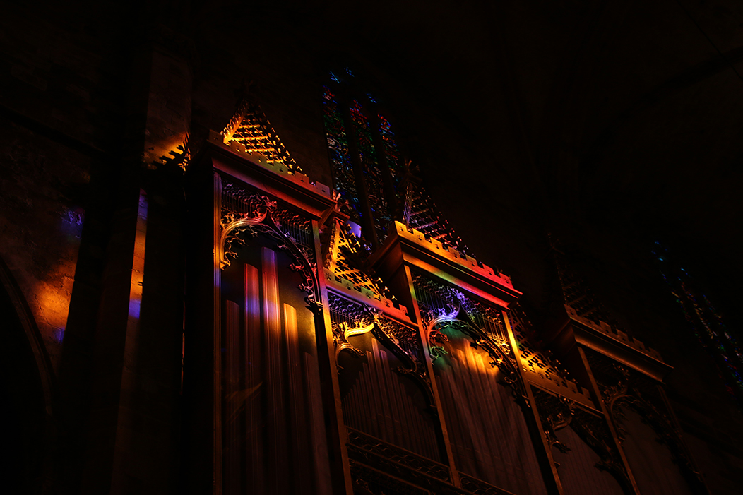 "Xogo de cores", fotografía tomada na Sé de Mallorca o 9-12-23. Mostra un dos órganos da Sé de Mallorca alumado soamente pola luz colorida que atravesa as vidreiras azuis, vermellas, verdes e amarelas do seu rosetón.